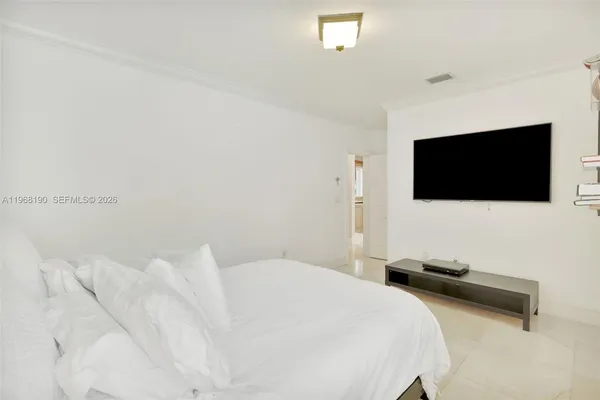 a bedroom with a bed tv and a flat screen tv