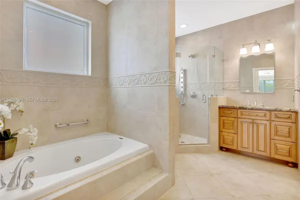 a bathroom with a tub a sink and a mirror