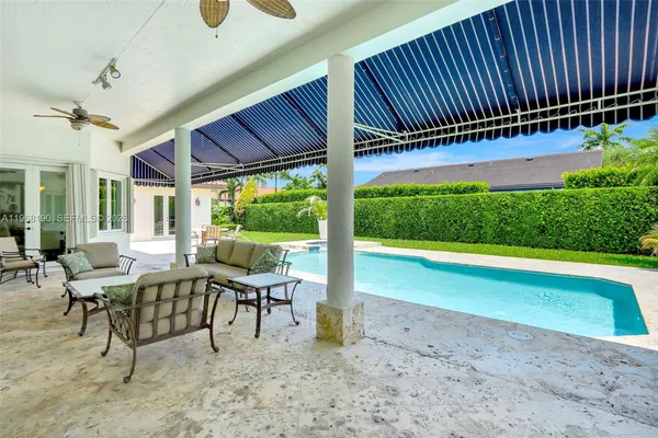 a view of swimming pool with lawn chairs and wooden fence