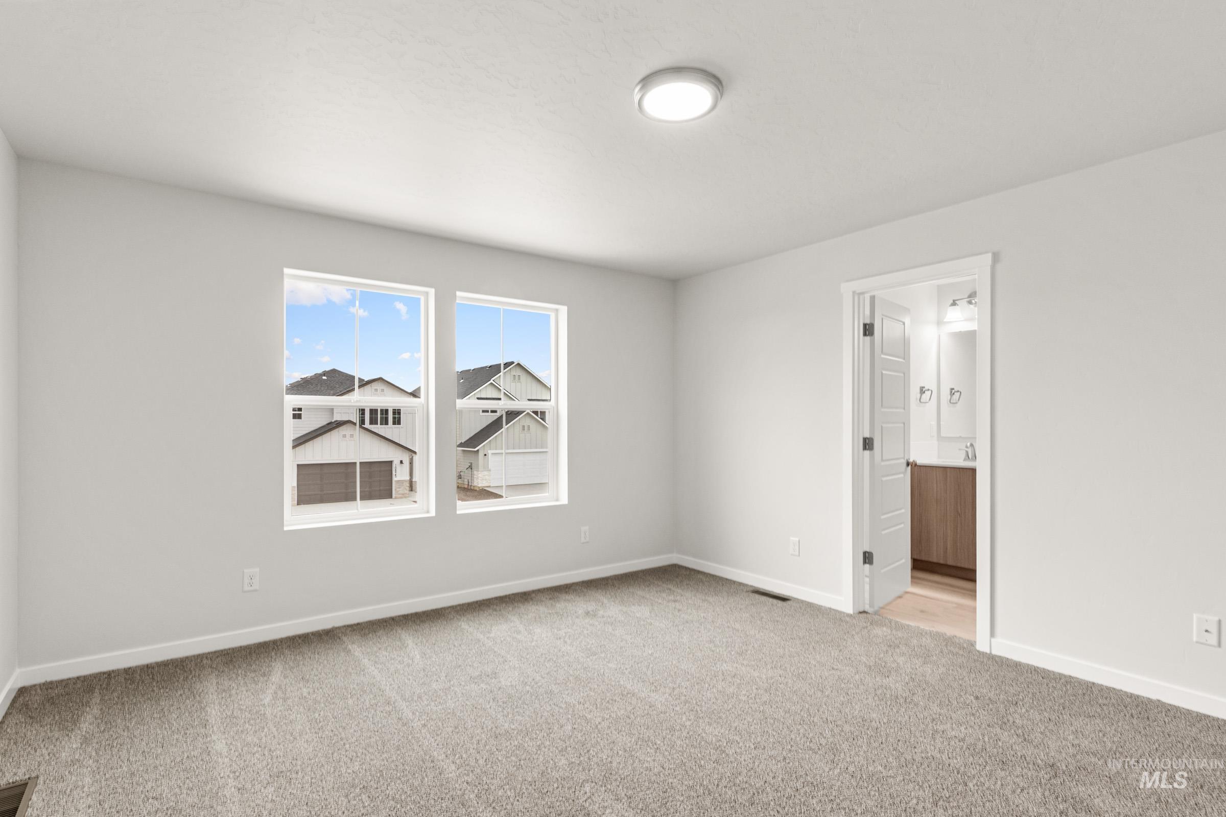 10824 Rutland Street Caldwell, ID 83605 - Photo 14 of 20 Empty room with light carpet and baseboards