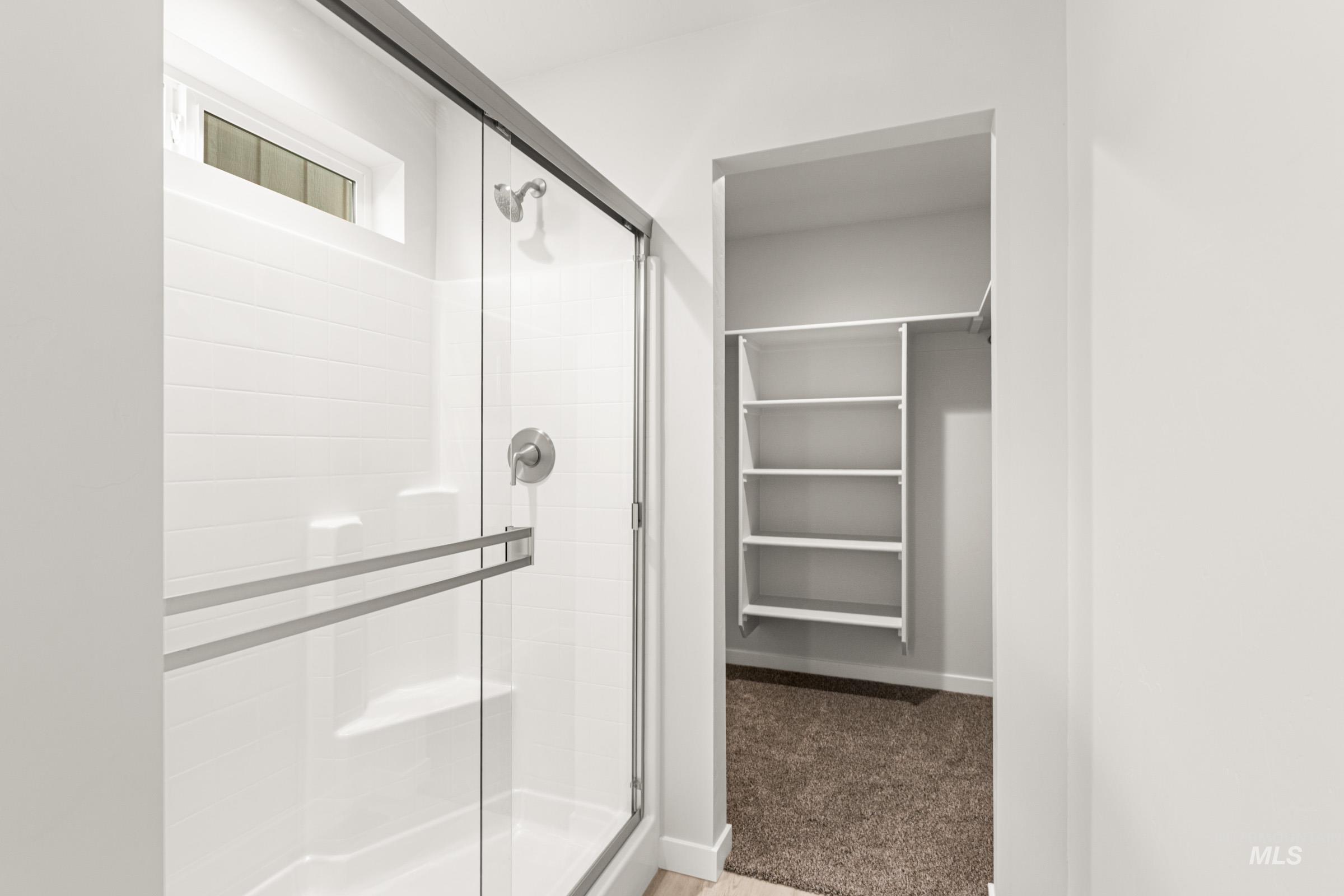 10824 Rutland Street Caldwell, ID 83605 - Photo 15 of 20 Bathroom with a shower stall, light carpet, and a spacious closet