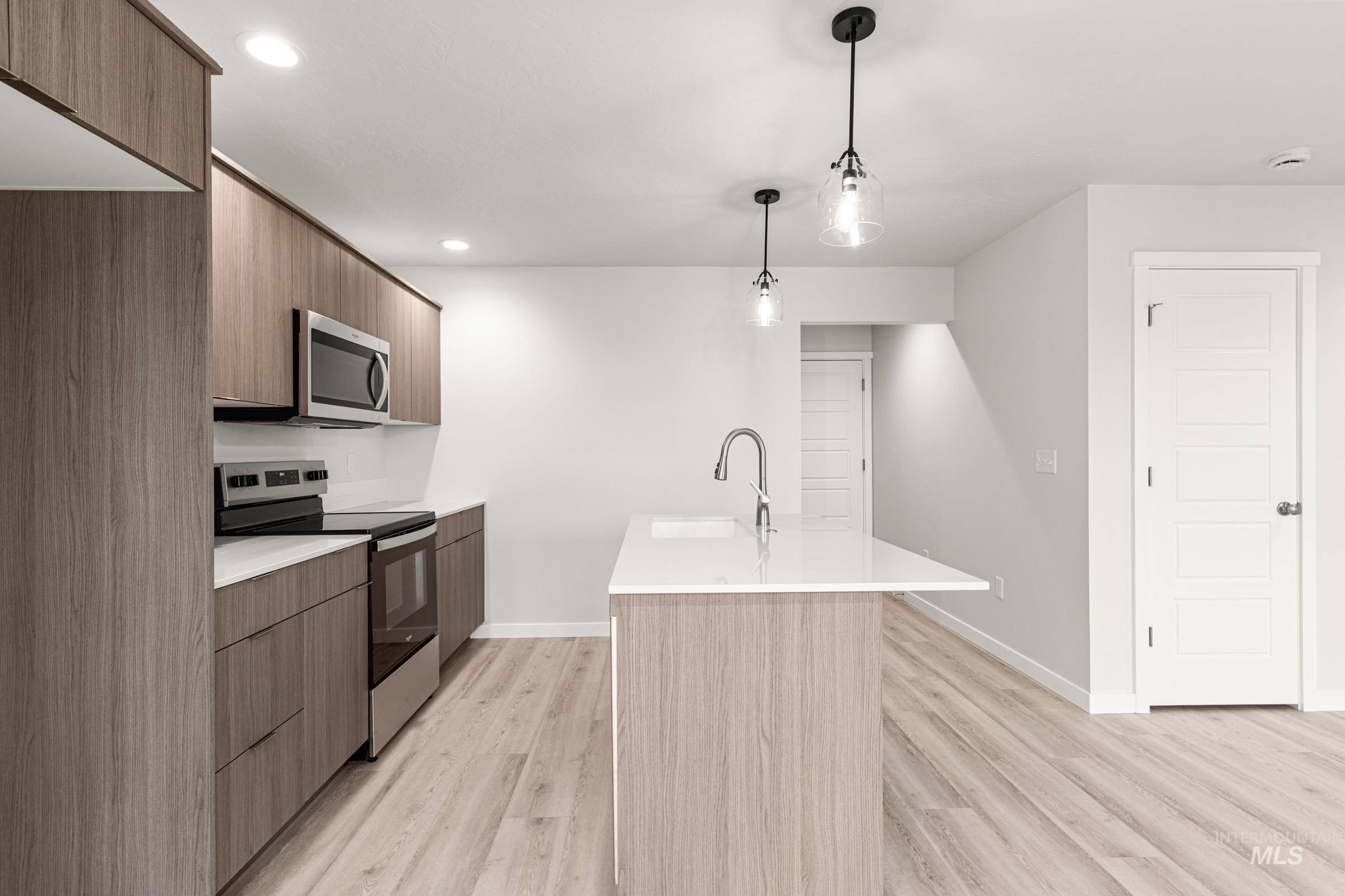 10824 Rutland Street Caldwell, ID 83605 - Photo 4 of 20 Kitchen featuring stainless steel appliances, modern cabinets, pendant lighting, and light wood-style floors