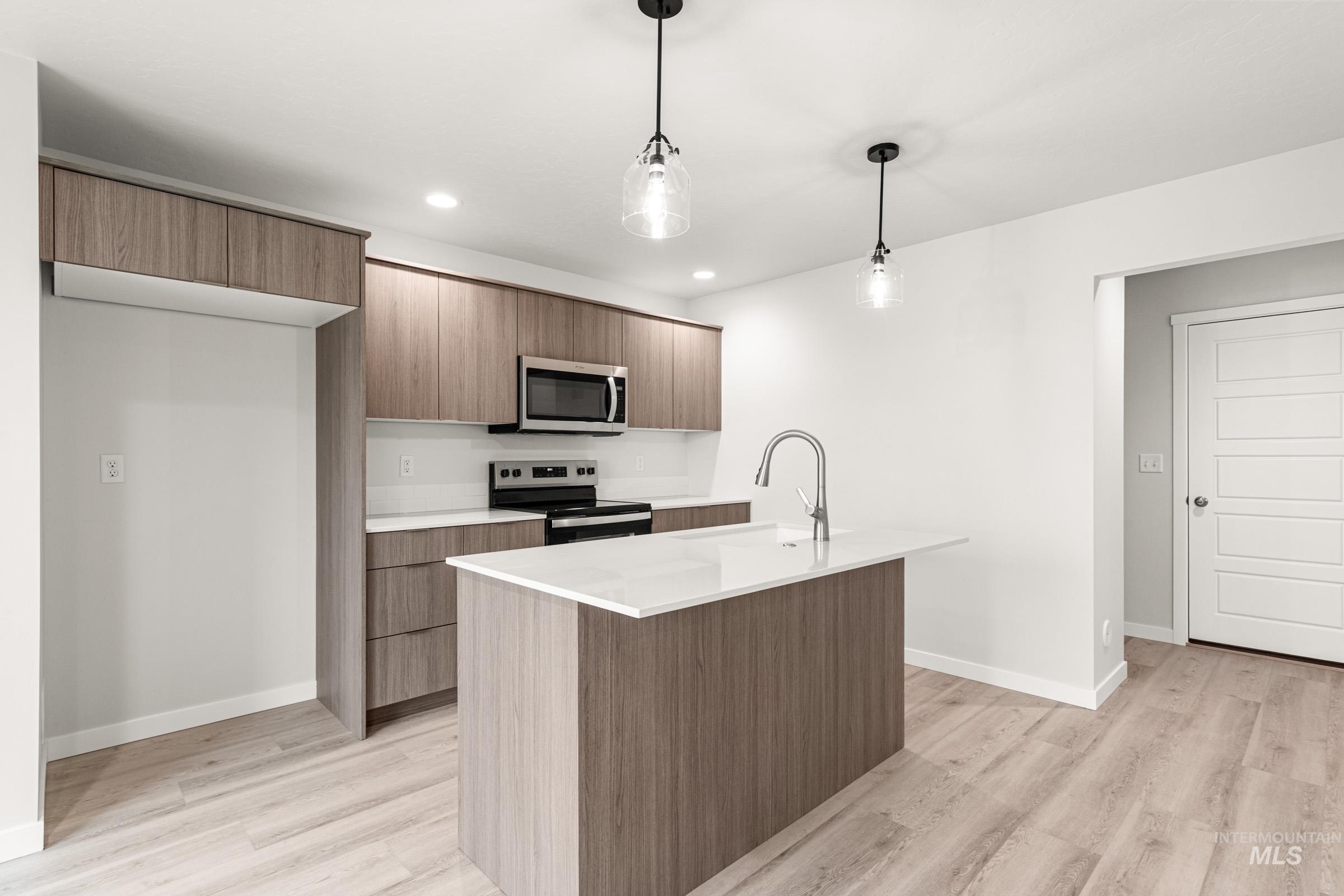 10824 Rutland Street Caldwell, ID 83605 - Photo 5 of 20 Kitchen with pendant lighting, stainless steel appliances, modern cabinets, and a center island with sink
