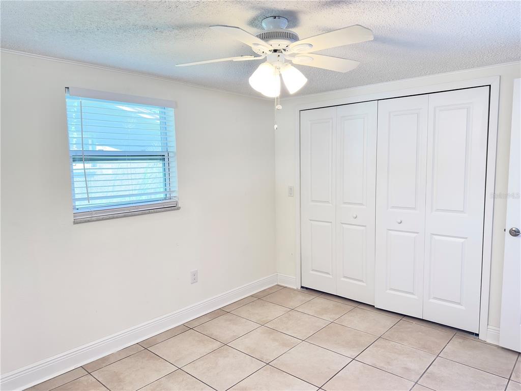 5701 Quist Drive Port Richey, FL 34668 - Photo 15 of 53 an empty room with windows and fan