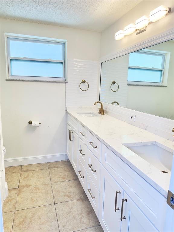 5701 Quist Drive Port Richey, FL 34668 - Photo 20 of 53 a bathroom with a granite countertop sink and a mirror