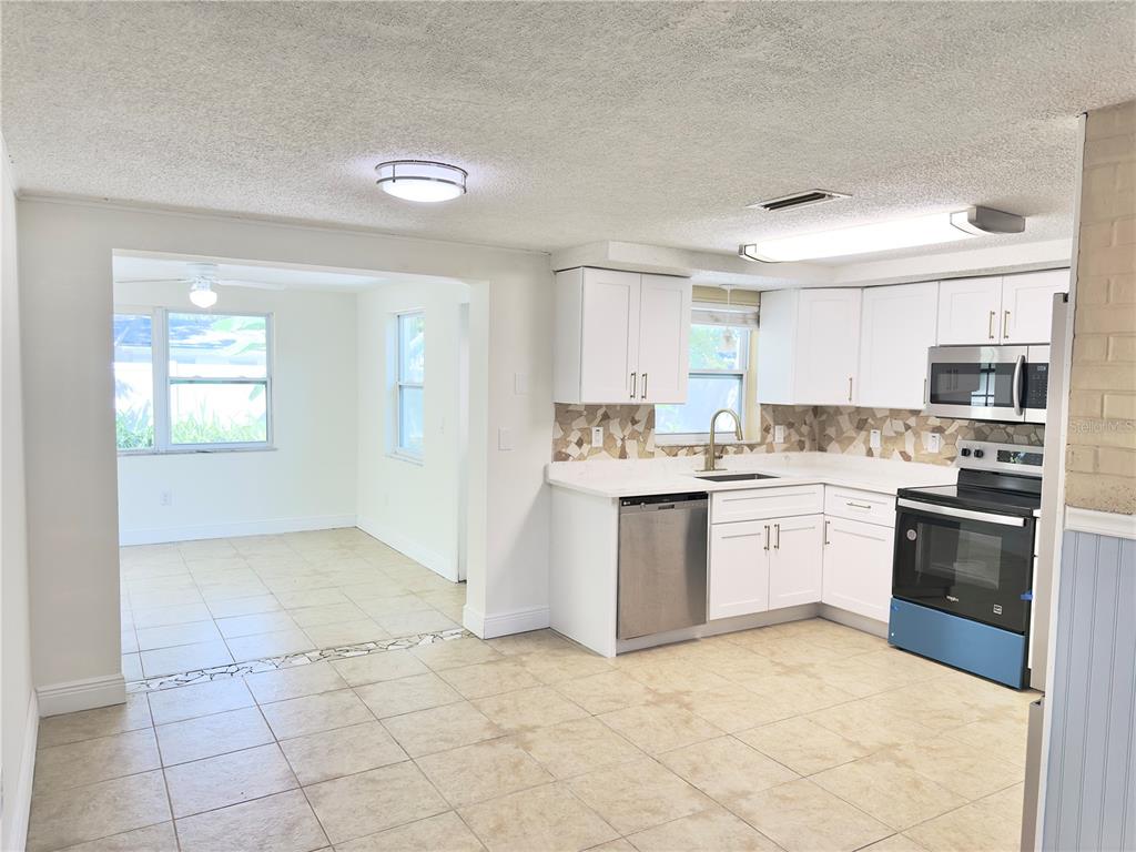 5701 Quist Drive Port Richey, FL 34668 - Photo 23 of 53 a kitchen with granite countertop a stove top oven sink and cabinets