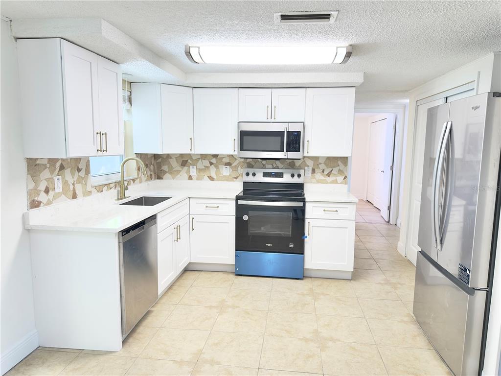 5701 Quist Drive Port Richey, FL 34668 - Photo 24 of 53 a kitchen with stainless steel appliances a stove sink and refrigerator