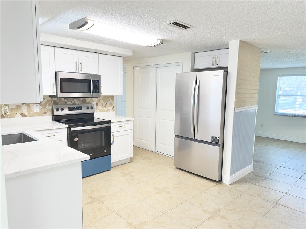 5701 Quist Drive Port Richey, FL 34668 - Photo 25 of 53 a kitchen with stainless steel appliances a stove a refrigerator and a microwave