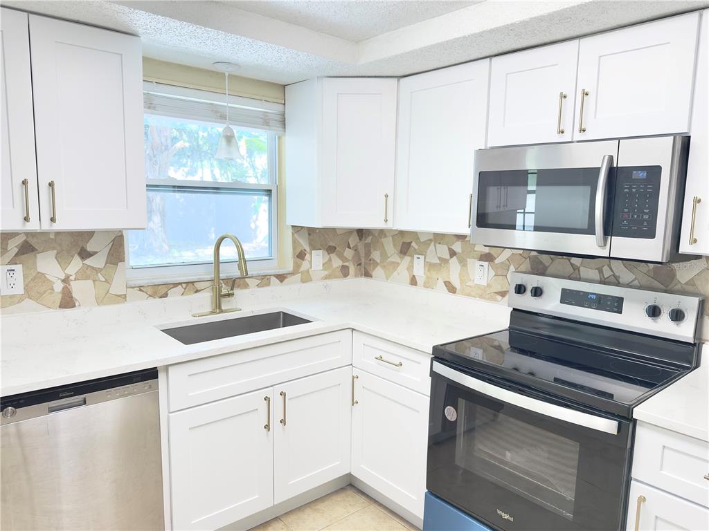 5701 Quist Drive Port Richey, FL 34668 - Photo 27 of 53 a kitchen with cabinets appliances a sink and a counter top space