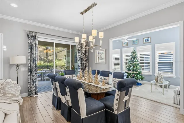 a view of a dining room and livingroom with furniture wooden floor a chandelier