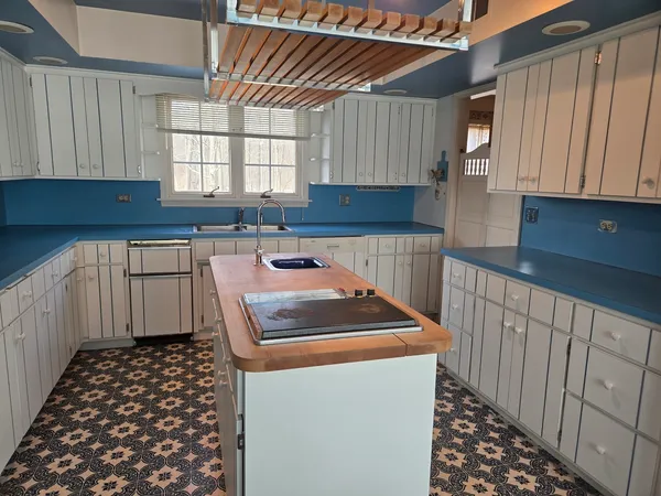 a kitchen with stainless steel appliances kitchen island granite countertop a sink a stove and white cabinets