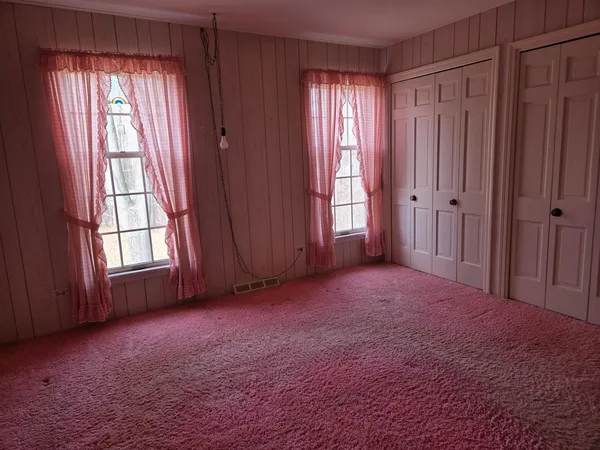 a spacious bedroom with a bed and a window