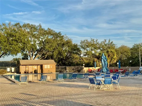 a view of a patio with table and chairs and potted plants with wooden floor and fence