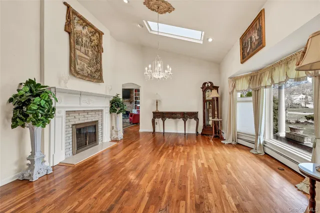 a furnished livingroom with a fireplace and windows