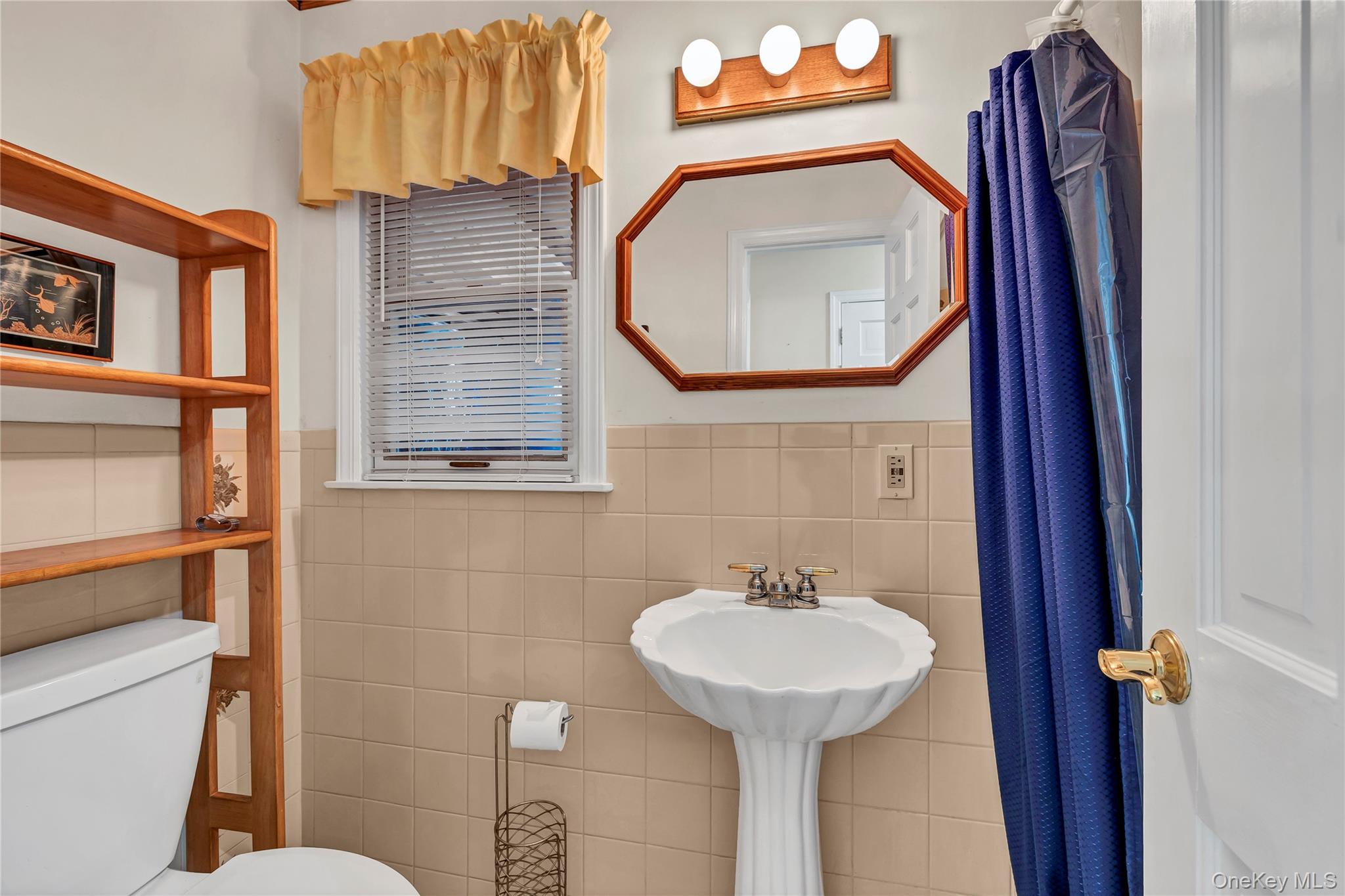 20 Oak Lane Hampton Bays, NY 11946 - Photo 19 of 45 Bathroom featuring toilet, tile walls, and wainscoting
