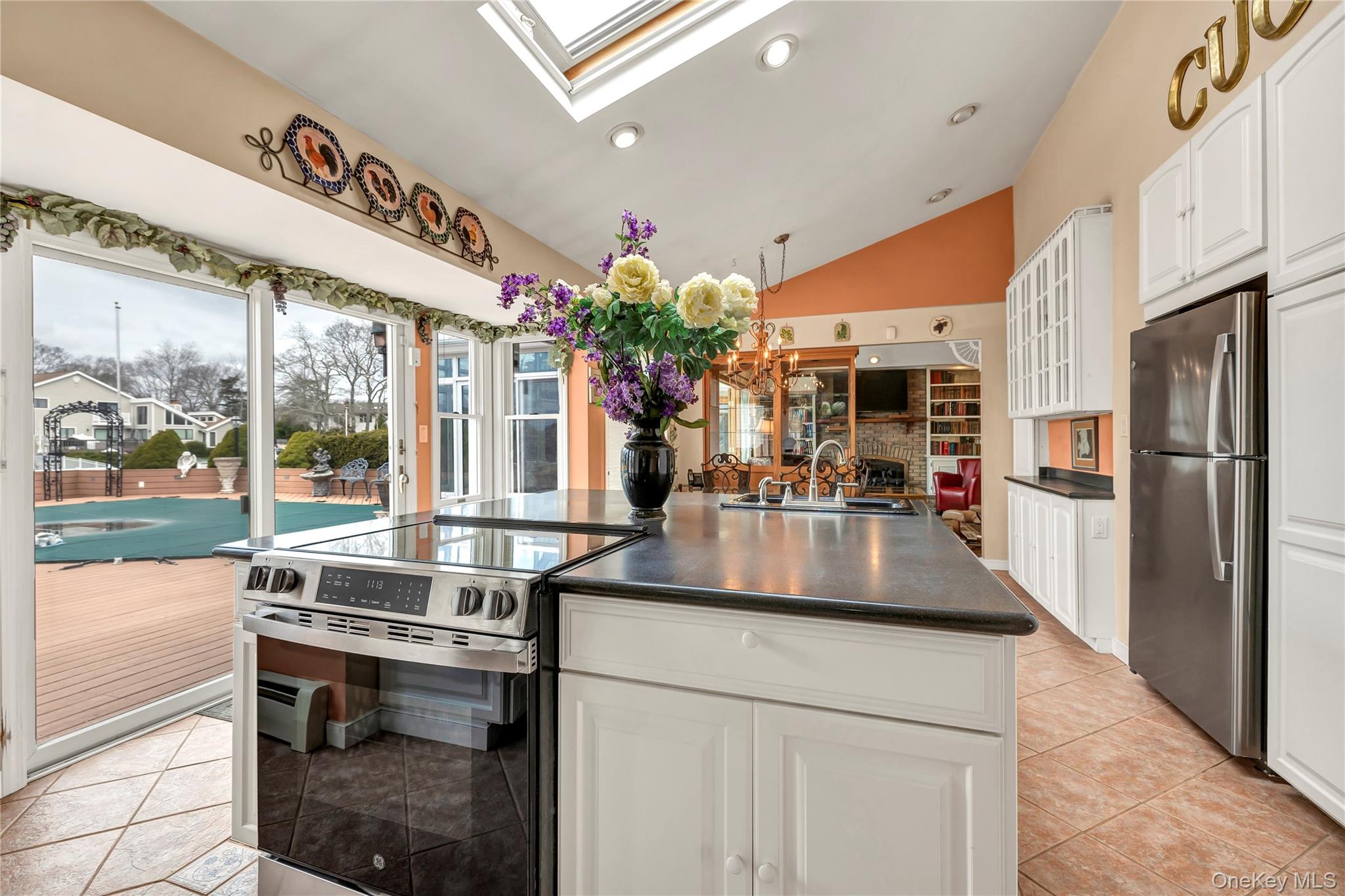20 Oak Lane Hampton Bays, NY 11946 - Photo 21 of 45 a kitchen with stainless steel appliances granite countertop a sink and a refrigerator