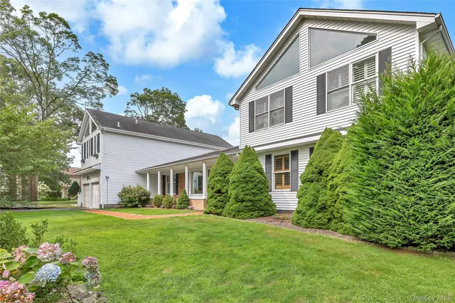 an aerial view of a house with a garden and lake view