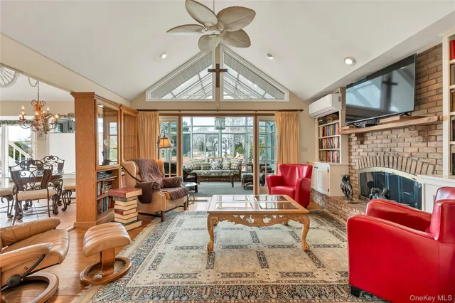 a living room with furniture a fireplace and a floor to ceiling window