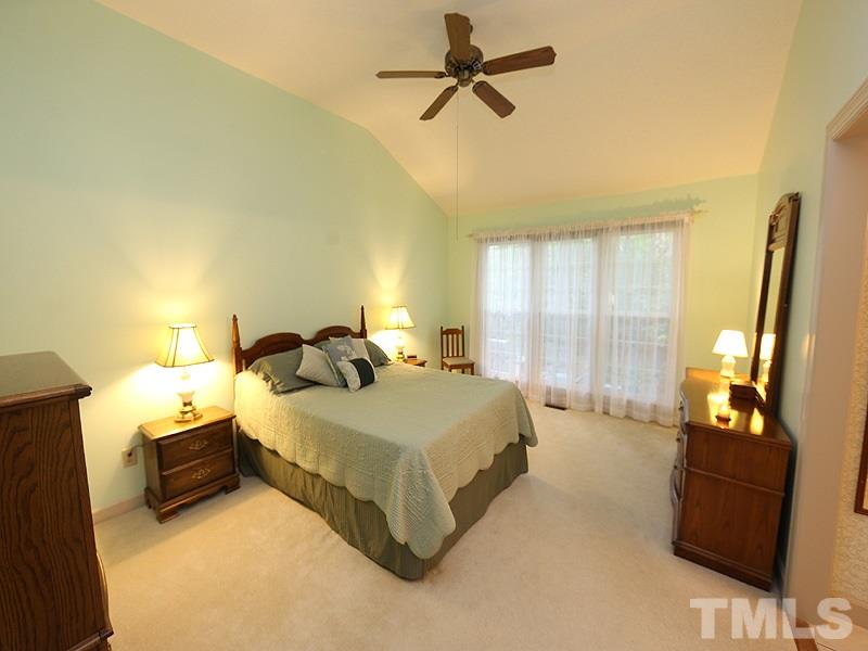 8121 Coleraine Court Raleigh, NC 27615 - Photo 8 of 17 a spacious bedroom with a bed and wooden floor