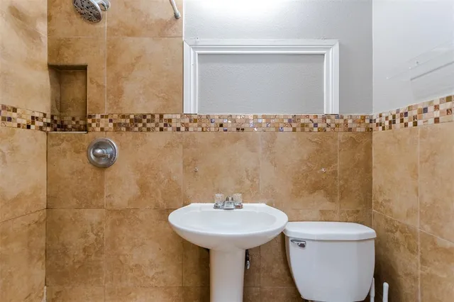 a bathroom with a sink a toilet and a mirror