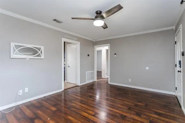 a view of an empty room with wooden floor