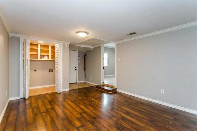 a view of an empty room with wooden floor