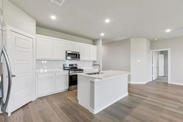 a kitchen with white cabinets and stainless steel appliances