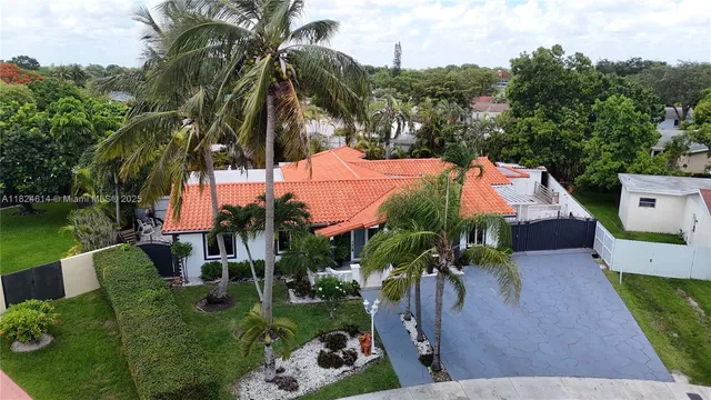 an aerial view of a house with a yard and swimming pool