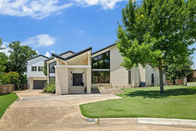 a front view of a house with a garden and yard