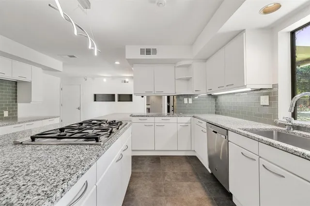 a kitchen with stainless steel appliances granite countertop a sink stove cabinets and a granite counter tops