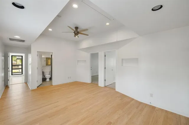 a big room with wooden floor and windows in a room