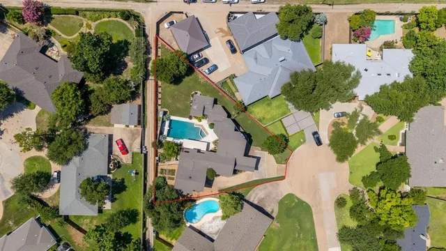 an aerial view of a house with a yard and a large tree