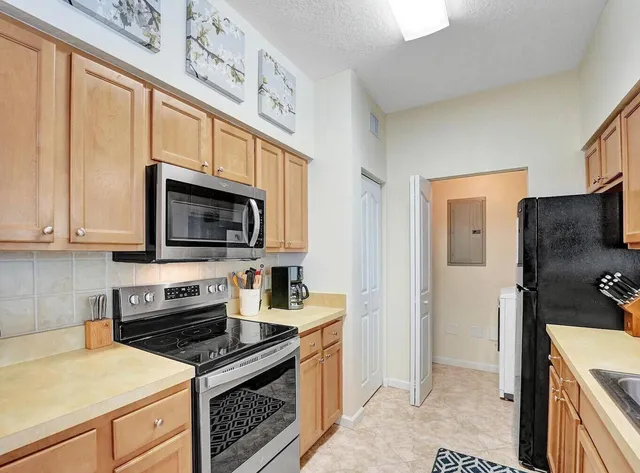 a kitchen with stainless steel appliances a stove microwave and sink