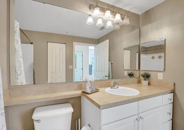 a bathroom with a sink vanity granite and toilet