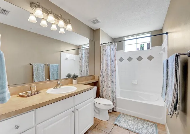 a bathroom with a double vanity sink mirror and toilet