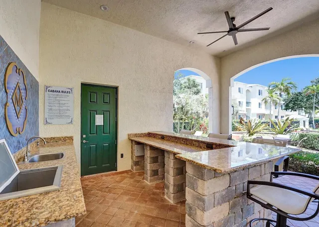 a view of a kitchen with a sink a dining table and chairs