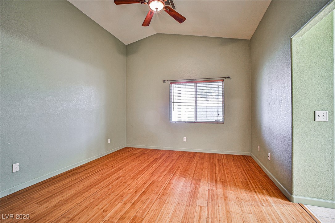 5128 Fall Meadows Avenue Las Vegas, NV 89130 - Photo 24 of 34 Spare room featuring a textured wall, light wood-type flooring, vaulted ceiling, and a ceiling fan