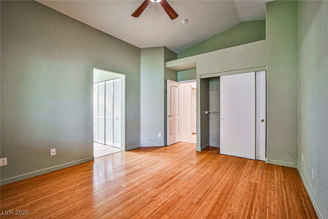 5128 Fall Meadows Avenue Las Vegas, NV 89130 - Photo 25 of 34 Unfurnished bedroom featuring lofted ceiling, light wood-style flooring, ceiling fan, and a textured wall