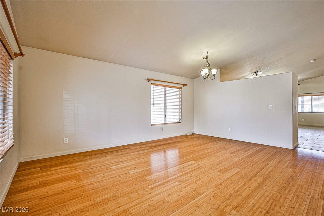 5128 Fall Meadows Avenue Las Vegas, NV 89130 - Photo 7 of 34 Spare room with a chandelier and light wood-style flooring