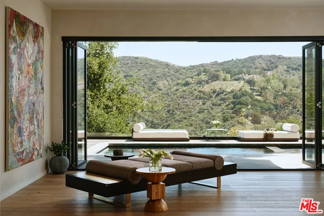 a view of a living room and floor to ceiling window with wooden floor