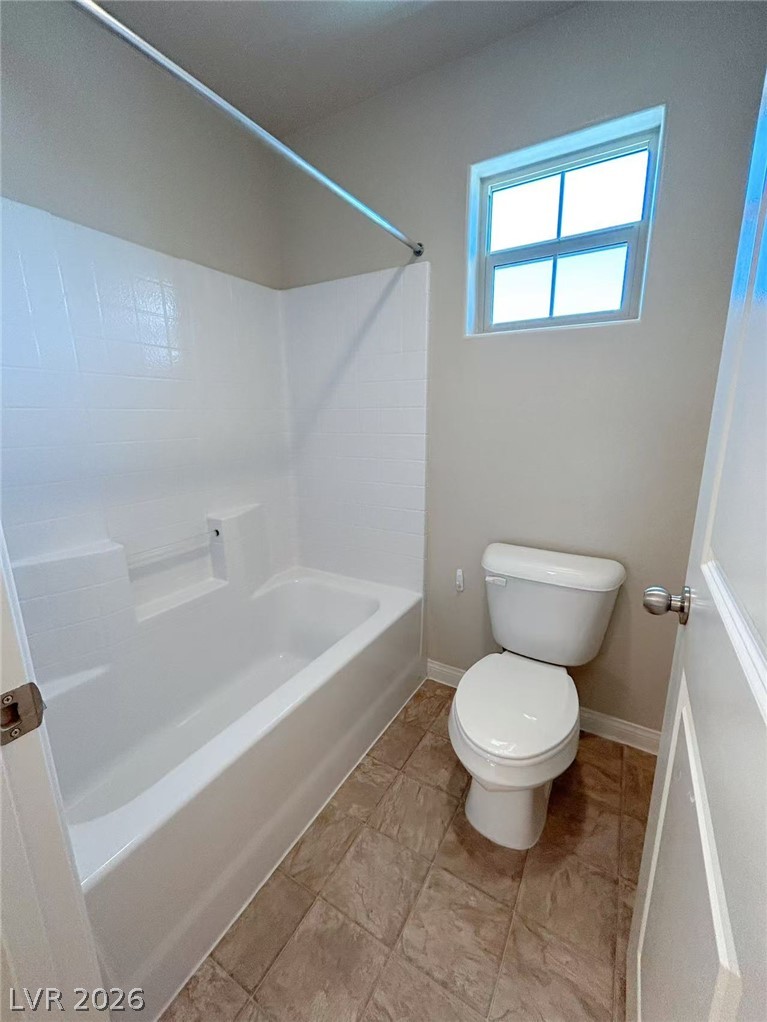 146 Tree Shot Court Las Vegas, NV 89113 - Photo 13 of 18 A well-maintained bathroom provides a pristine tub and toilet, illuminated by a high-set window.