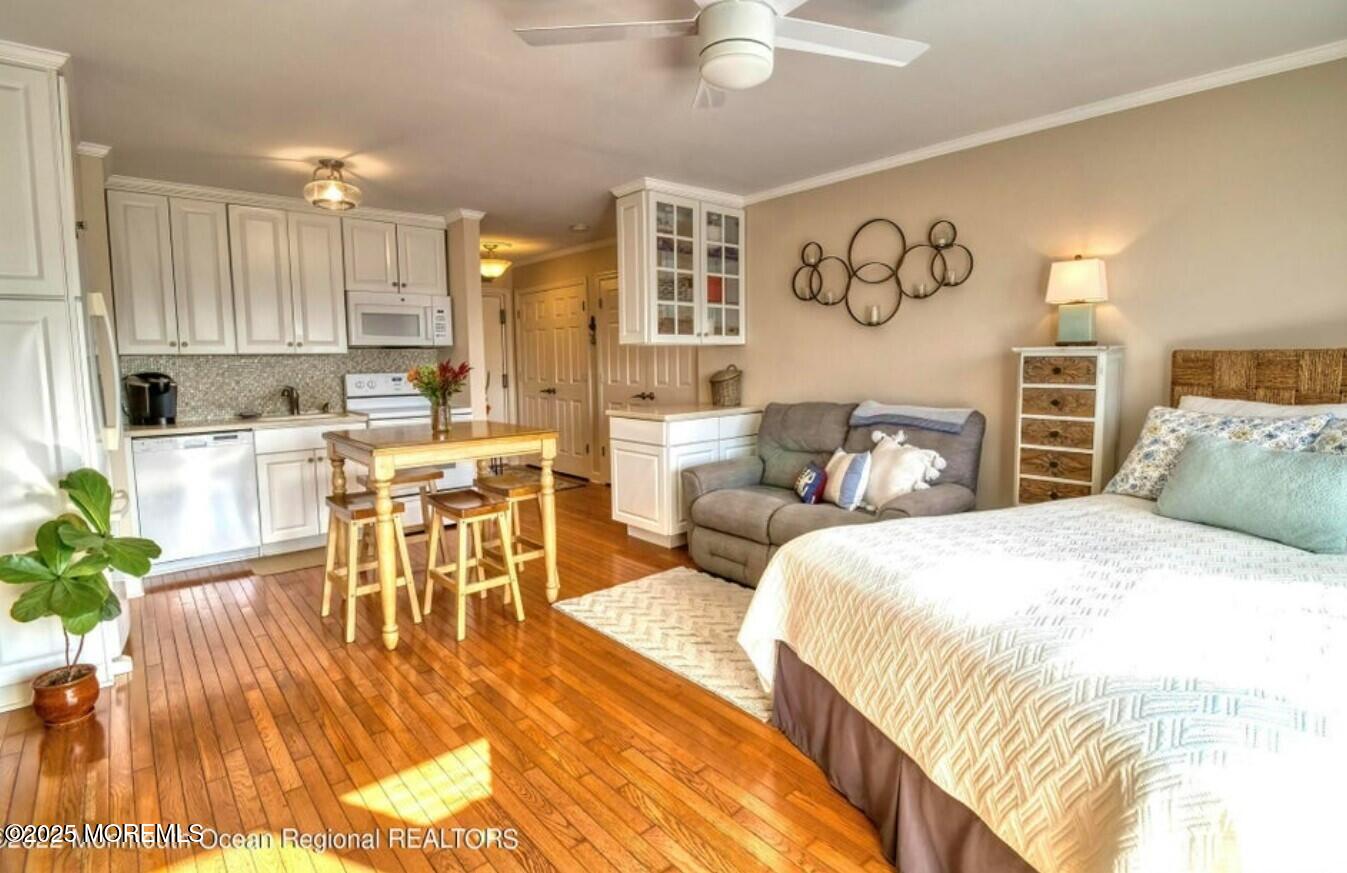 5 Ocean Avenue, Unit 5B Belmar, NJ 07719 - Photo 7 of 13 a spacious bedroom with a bed a table and potted plants with wooden floor