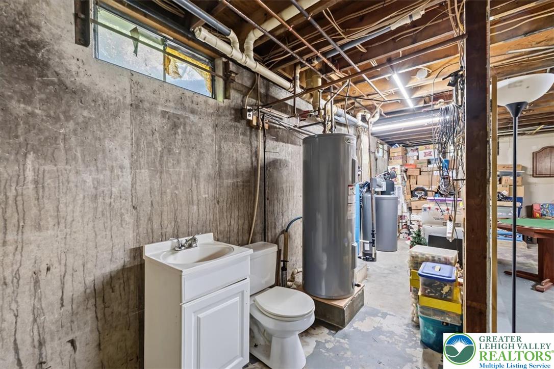 5340 2nd Street Whitehall, PA 18052 - Photo 23 of 30 A partially finished basement offers ample storage and utility space, featuring exposed concrete walls and overhead piping.