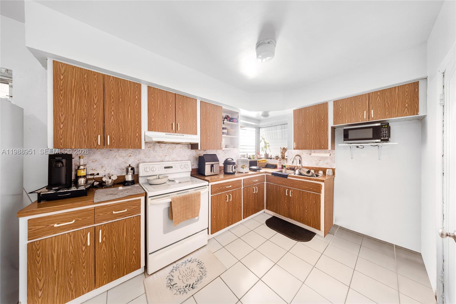 605 Northwest 34th Avenue Miami, FL 33125 - Photo 17 of 49 a kitchen with a stove top oven sink and cabinets