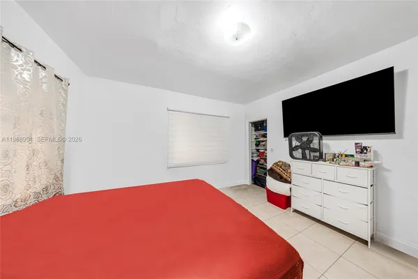 a bedroom with a bed a flat screen tv and a couch