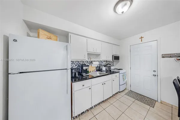 a kitchen with granite countertop cabinets and chairs