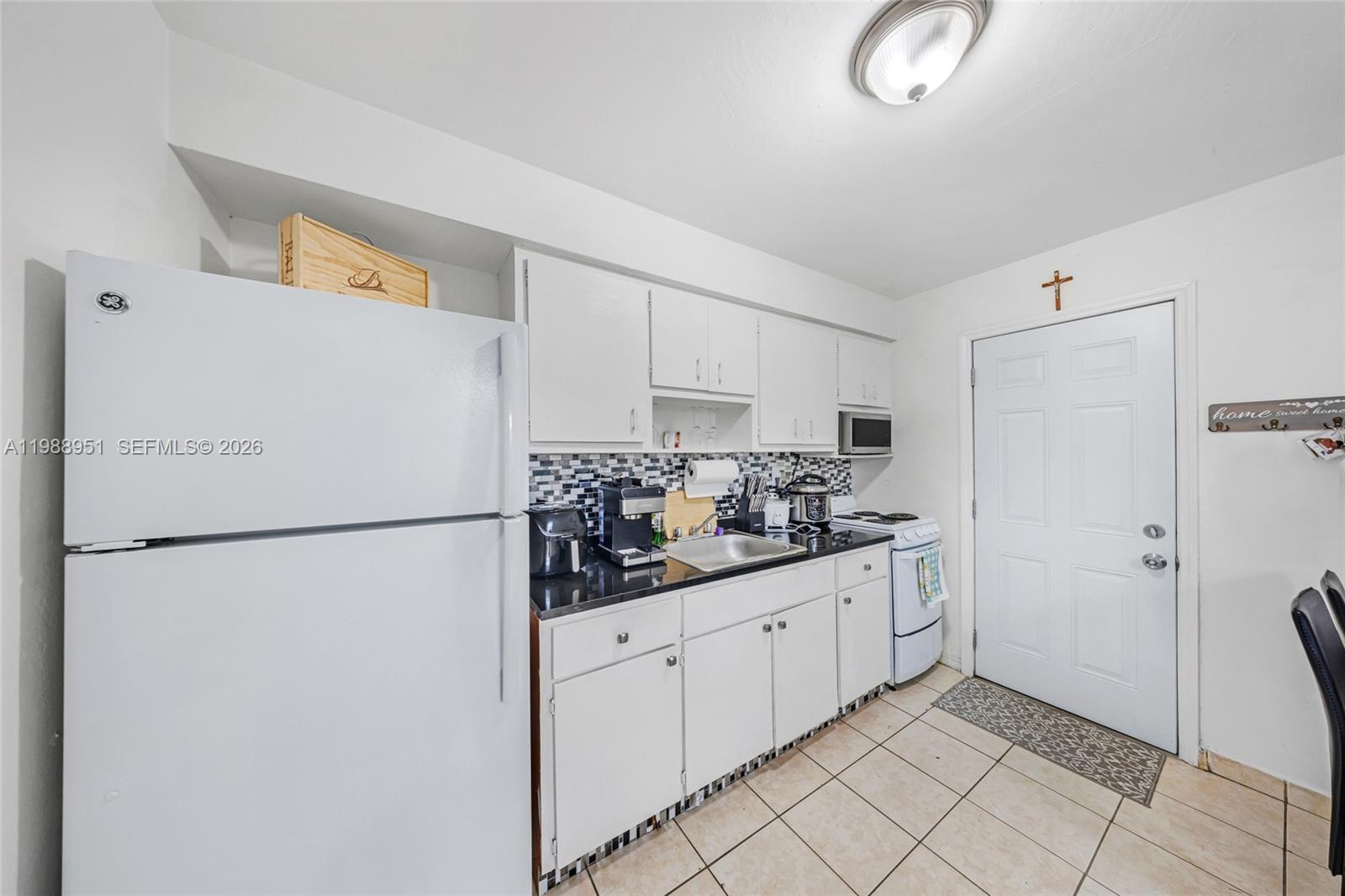 605 Northwest 34th Avenue Miami, FL 33125 - Photo 44 of 49 a kitchen with white cabinets and refrigerator