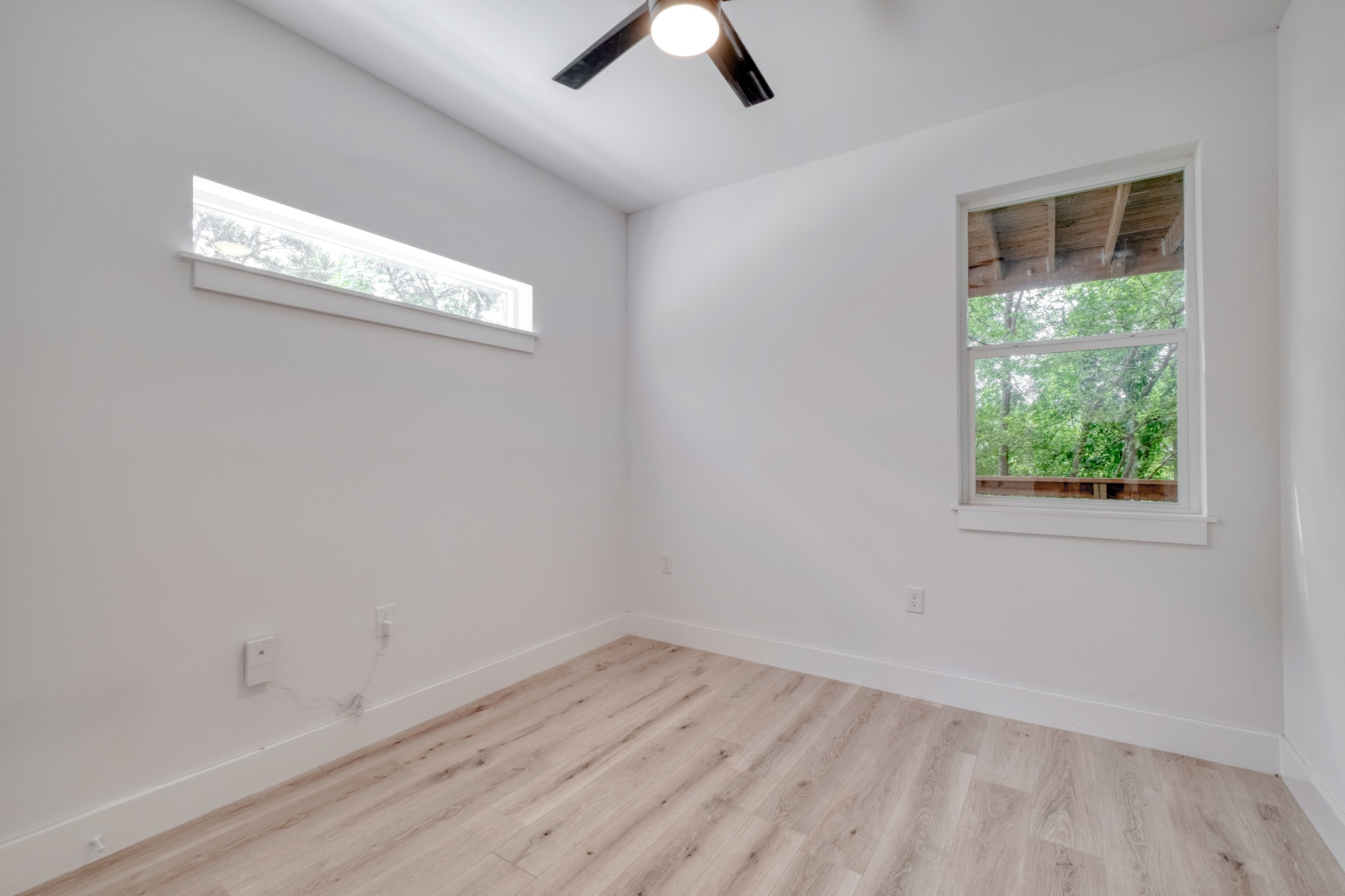 5211 Rob-Scott Street Austin, TX 78721 - Photo 18 of 24 A quiet bedroom featuring light-toned flooring and two distinct windows inviting natural light.