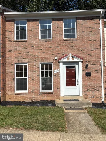 a view of a brick house with a yard