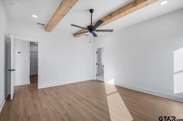 a view of a big room with wooden floor and a ceiling fan